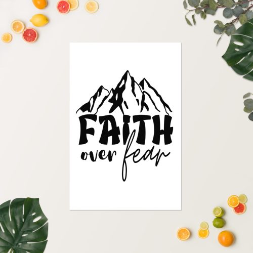 The "Faith Over Fear Poster," featuring an illustration of mountain peaks and the phrase "Faith over Fear" in bold, black lettering, is displayed on a light-colored surface adorned with various green leaves and colorful citrus fruits. This poster makes for an ideal Christian gift. christian gifts, religious gifts, gifts of faith, faith based gifts, faith inspired gifts