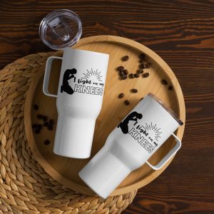 Two "I Fight On My Knees" travel mugs with lids sit on a round wooden tray scattered with coffee beans. Adorned with a graphic of a person kneeling and praying alongside the text "I fight on my KNEES," these white mugs make perfect gifts for the faithful. A woven placemat beneath the tray rests elegantly on the dark wooden table. christian gifts, religious gifts, gifts of faith, faith based gifts, faith inspired gifts