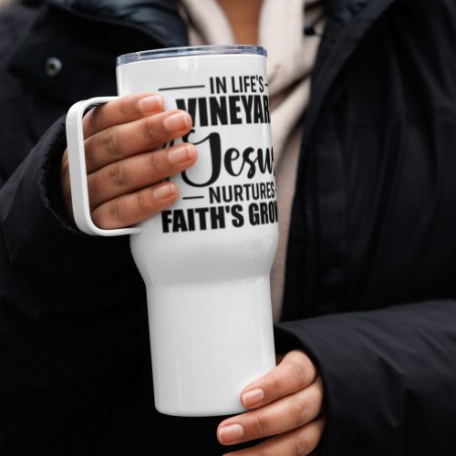 A person in a black coat holds an In Life's Vineyard Jesus Nurtures Faith's Growth Travel Mug. The person's fingernails are painted peach. The background is blurred, focusing on the mug and the person's hands. christian gifts, religious gifts, gifts of faith, faith based gifts, faith inspired gifts