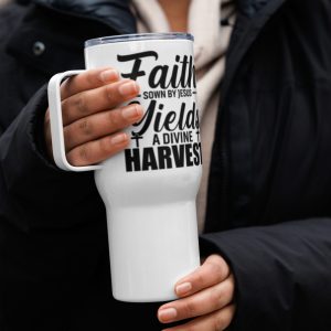 A person dressed in a black coat and light-colored scarf holds a large white mug with a handle. The mug has black text that reads, "Faith Sown By Jesus Yields A Divine Harvest Travel Mug. christian gifts, religious gifts, gifts of faith, faith based gifts, faith inspired gifts