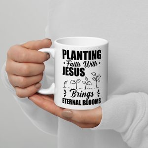 A person wearing a white sweater is holding a Planting Faith With Jesus Brings Eternal Blooms Coffee Cup. The mug also features an illustration of small plants growing from the ground. christian gifts, religious gifts, gifts of faith, faith based gifts, faith inspired gifts