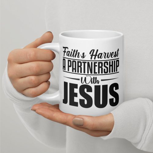 A light-skinned individual, donning a white long-sleeved shirt, holds a Faith's Harvest A Partnership With Jesus Coffee Cup. The cup features black text that reads, "Faith's Harvest A Partnership With Jesus." The person's neatly manicured nails complement the plain and neutral background—ideal for highlighting Christian gifts. christian gifts, religious gifts, gifts of faith, faith based gifts, faith inspired gifts