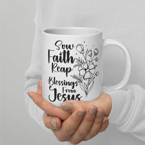 A person holding a Sow Faith Reap Blessings From Jesus Coffee Cup, featuring a white background with a floral design and the text "Sow Faith Reap Blessings From Jesus" in black, making it an ideal thoughtful religious gift. christian gifts, religious gifts, gifts of faith, faith based gifts, faith inspired gifts