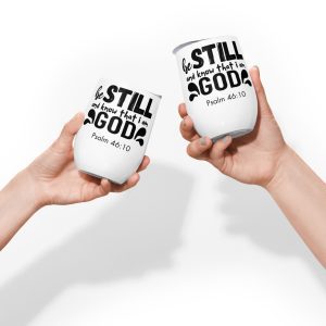 Two hands are holding Be Still and Say that I Am God "Psalm 46:10" Wine Tumblers with black text. The text reads, "be STILL and know that I am GOD," followed by "Psalm 46:10." These Christian gifts are positioned against a plain white background, making them perfect religious gifts for loved ones. christian gifts, religious gifts, gifts of faith, faith based gifts, faith inspired gifts